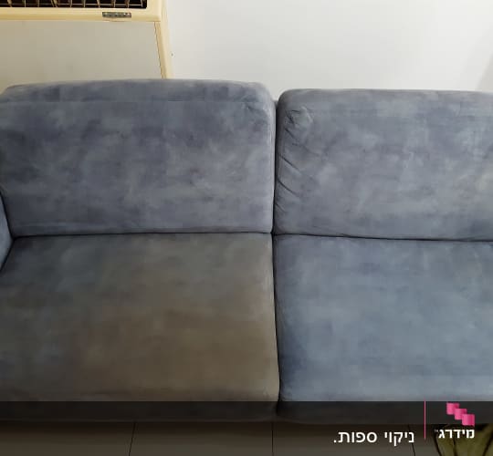 ספה עם כתם כהה בצד אחד, מגבת צהובה על הרצפה